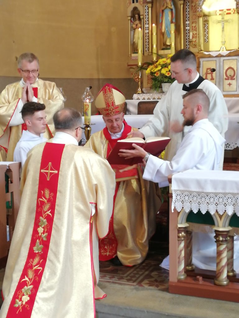 Piotr Kowalczyk klęczy przed biskupem